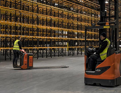 Warehouse Racking with Workers on Forklift Trucks
